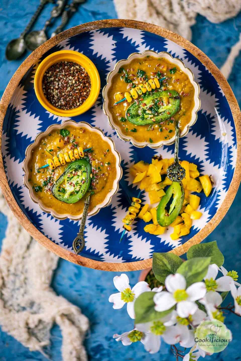 2 bowls of mango soup served in a round platter