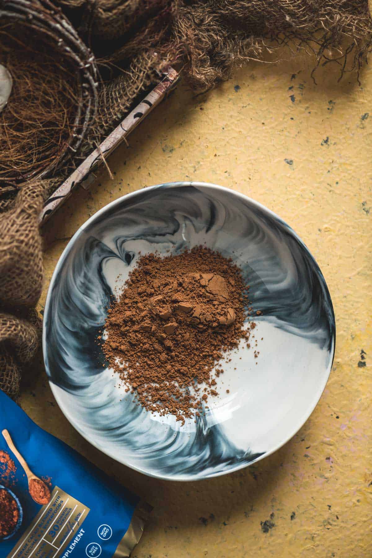 Cacao powder in a mixing bowl for homemade vegan chocolate bars.