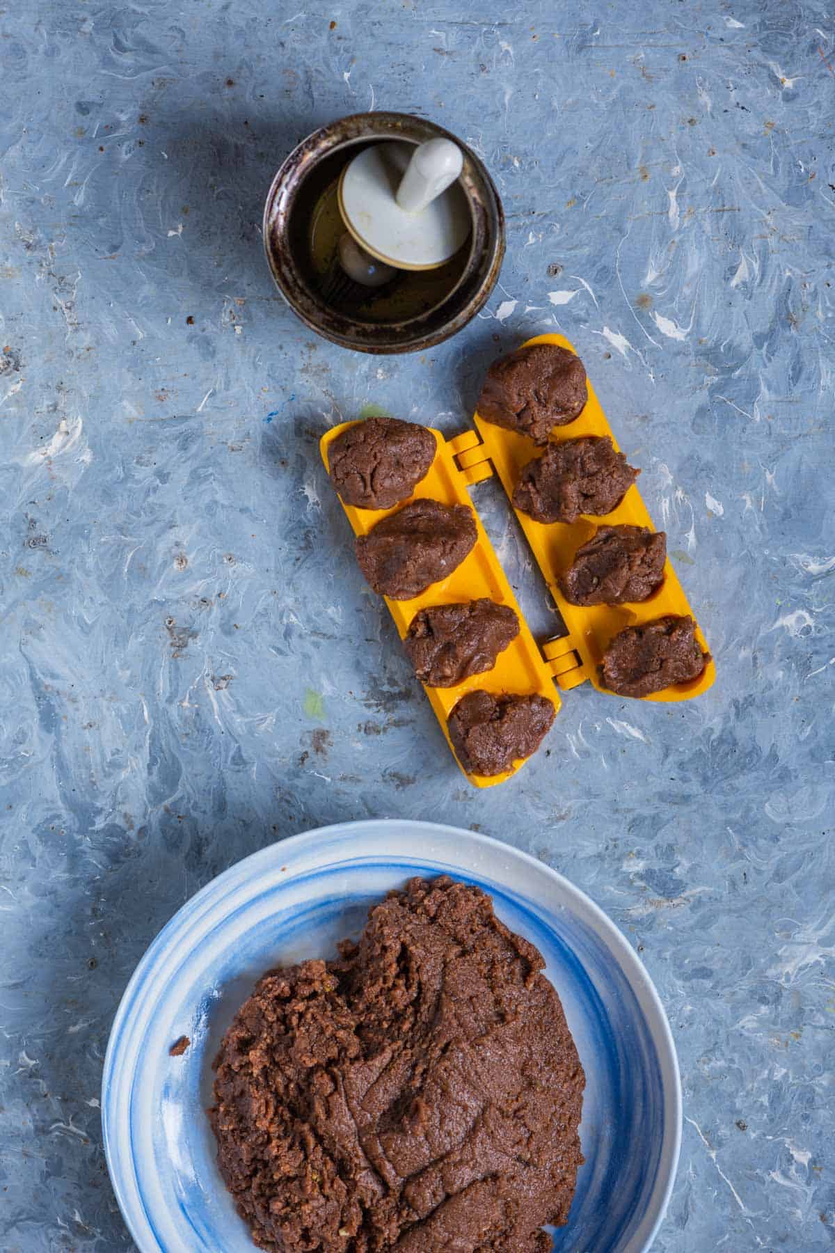 Chocolate modak mixture stuffed into a greased mold.