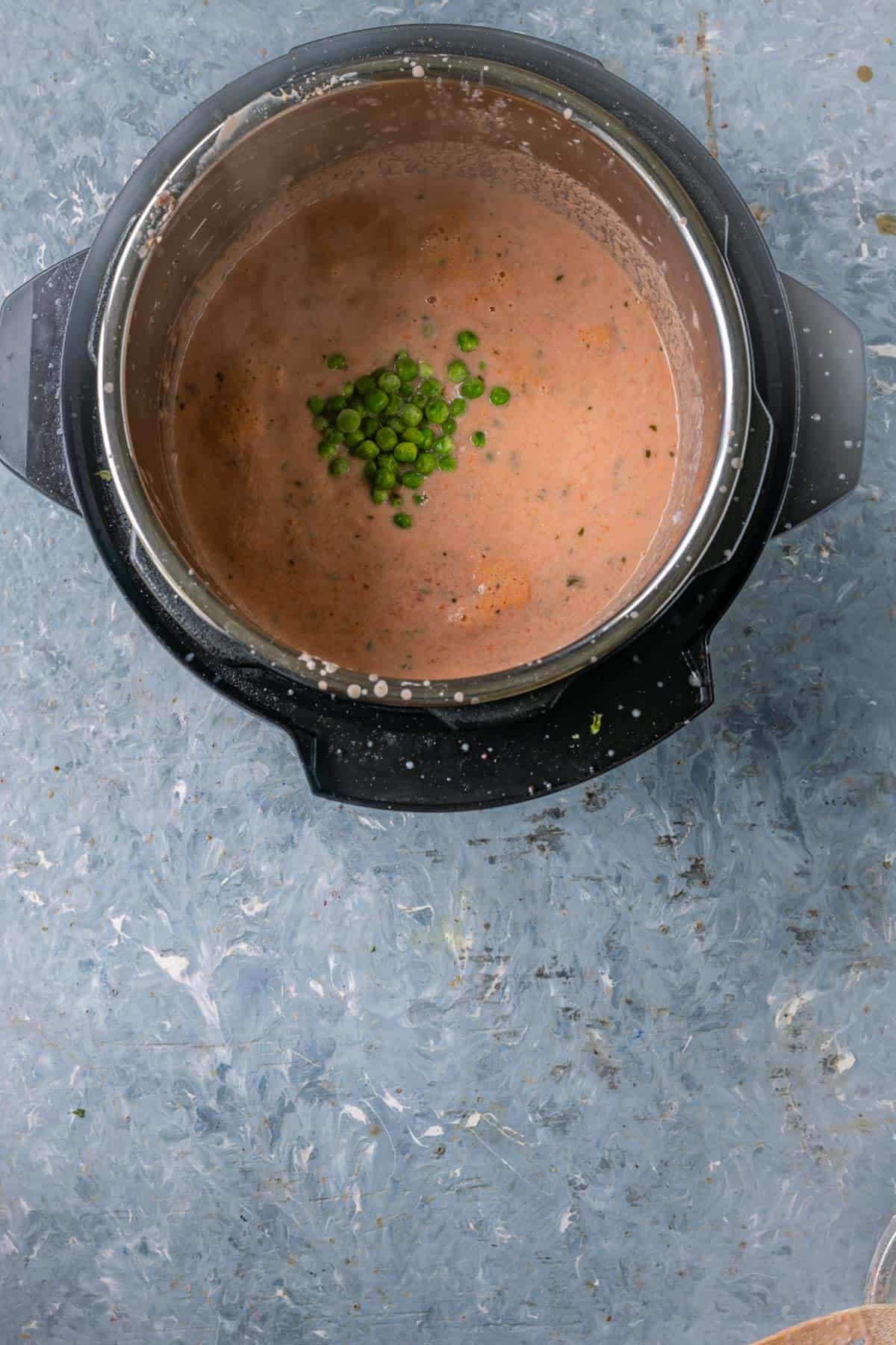 Green peas added to curry with water in Instant Pot.