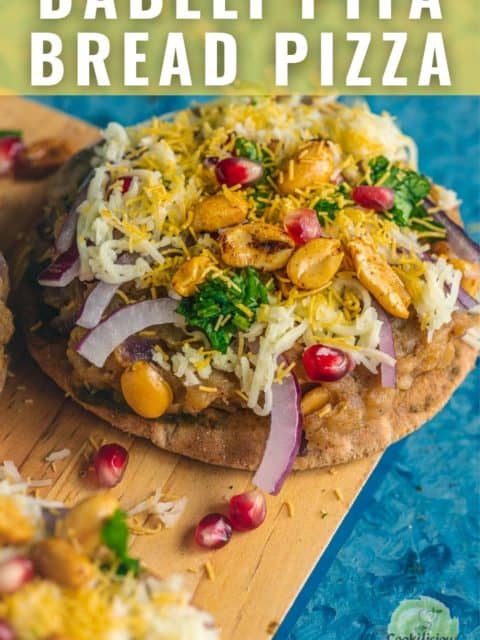 Dabeli Pita Bread Pizza garnished with sev and peanuts on top and text at the top