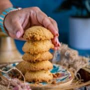 a hand picking up one Whole Wheat Ghee Cookie from a stack
