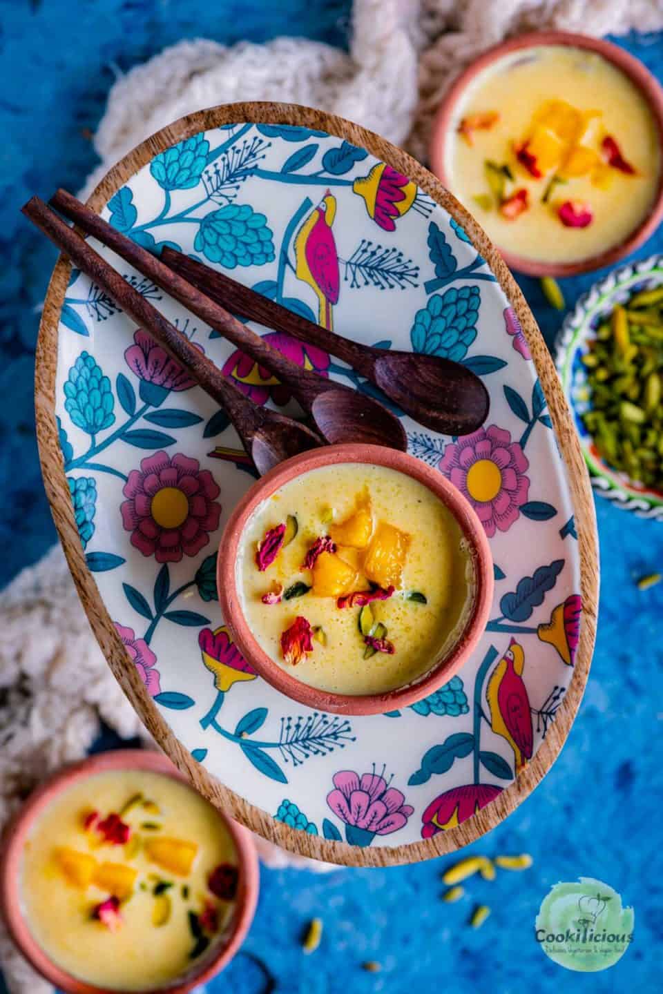 mango phirni served in a tray with spoons on the side.