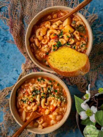 2 bowls filled with Minestrone Soup and spoons in them