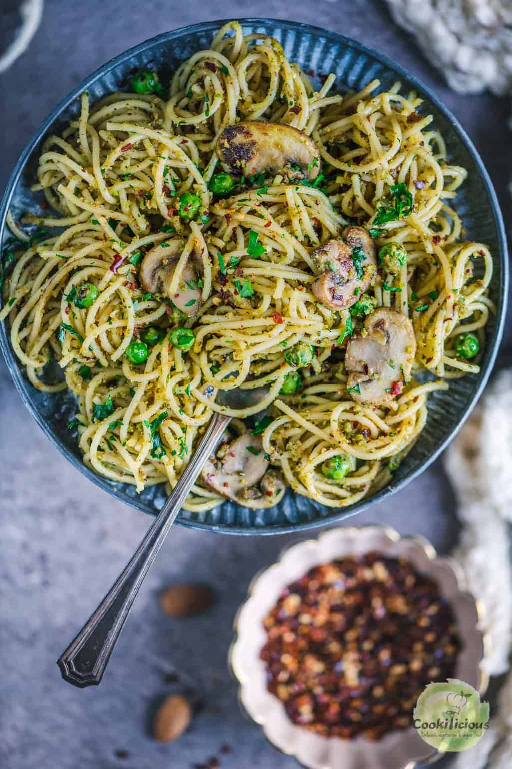 Almond Picada Pesto Spaghetti served in a plate with a fork in it
