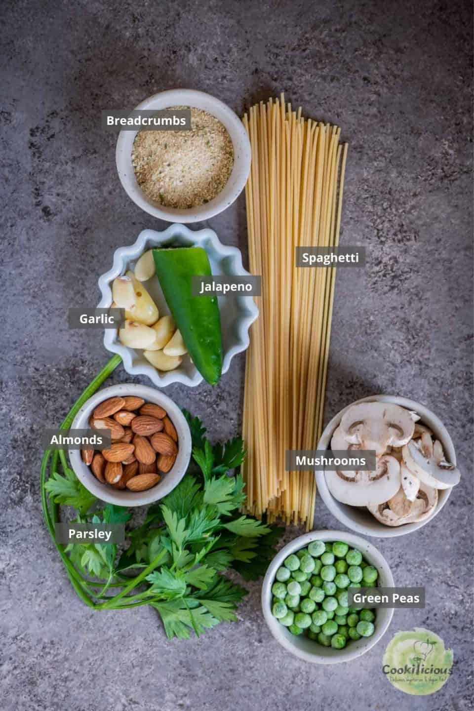 all the ingredients needed to make Almond Picada Pesto Spaghetti placed on the table with labels on them