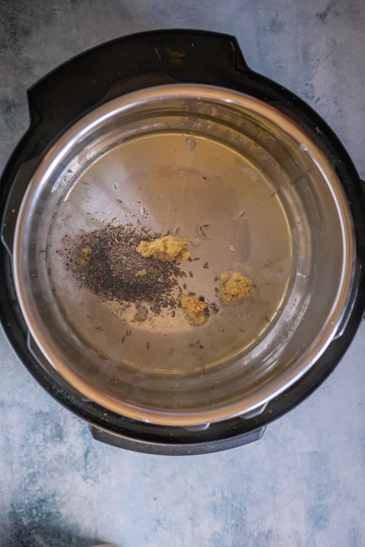 Tempering cumin, ginger, and black pepper in ghee in the Instant Pot for Ven Pongal.