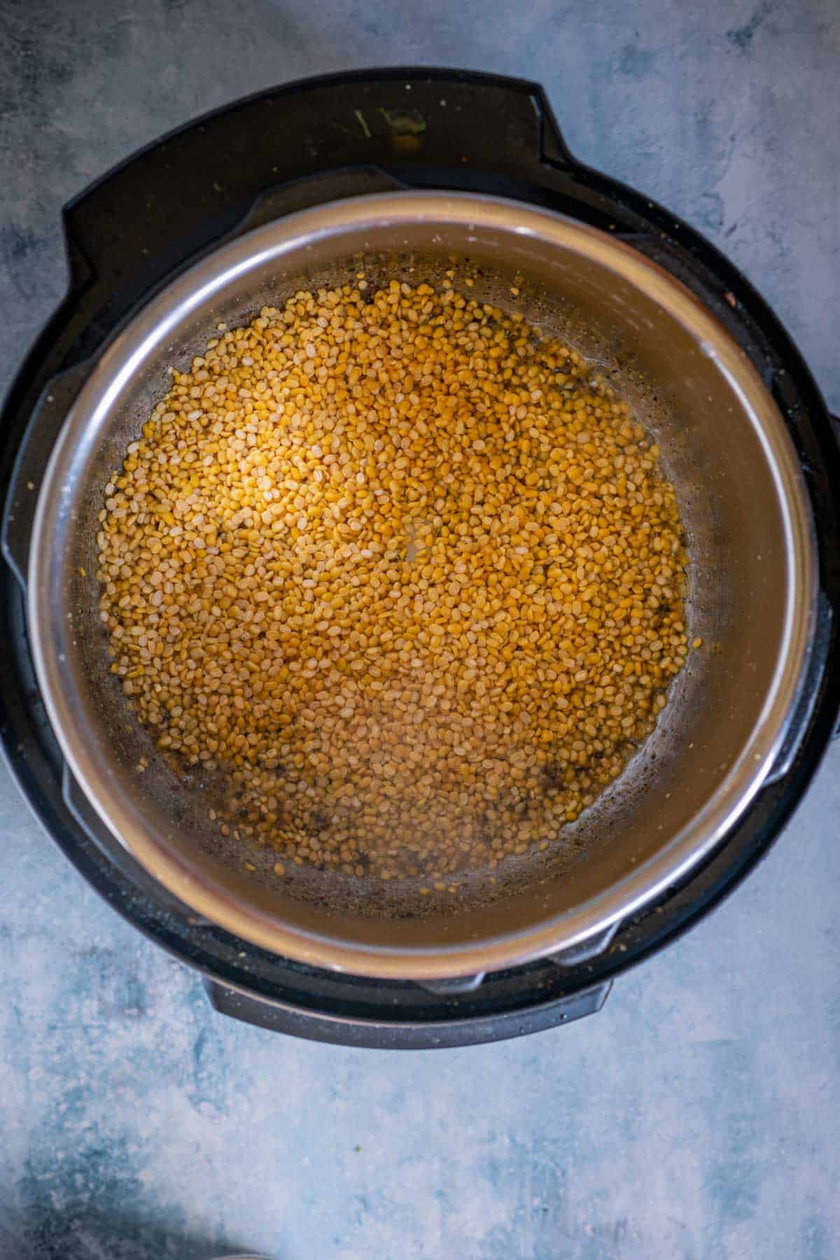 Moong dal being sautéed with spices in the Instant Pot for Khara Pongal.