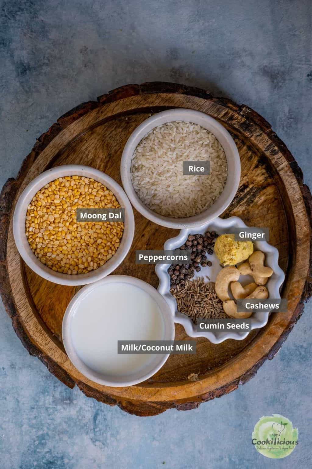 Ingredients for Instant Pot Ven Pongal including rice, moong dal, black pepper, cumin, ginger, cashews, milk, and ghee arranged on a countertop.