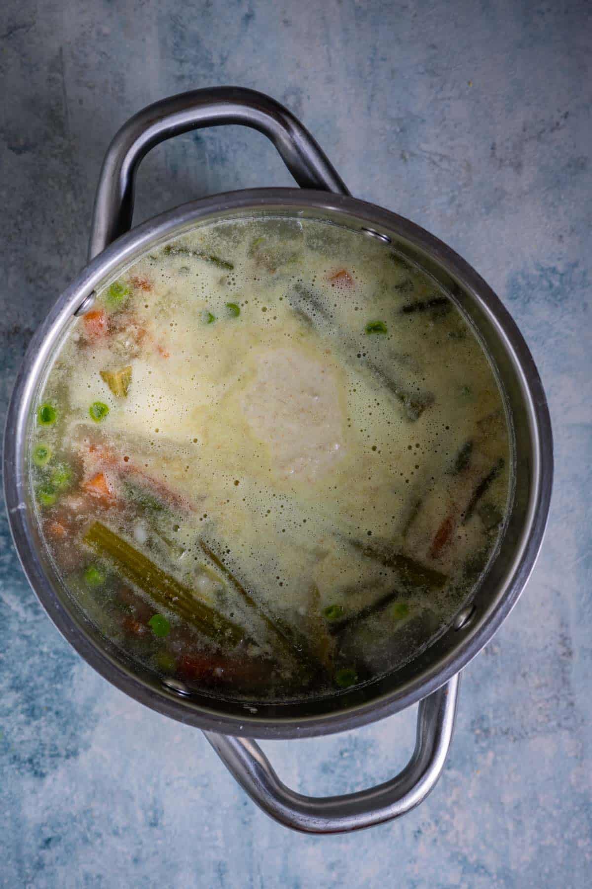 Coconut-yogurt paste added to the cooked vegetables in the pot.