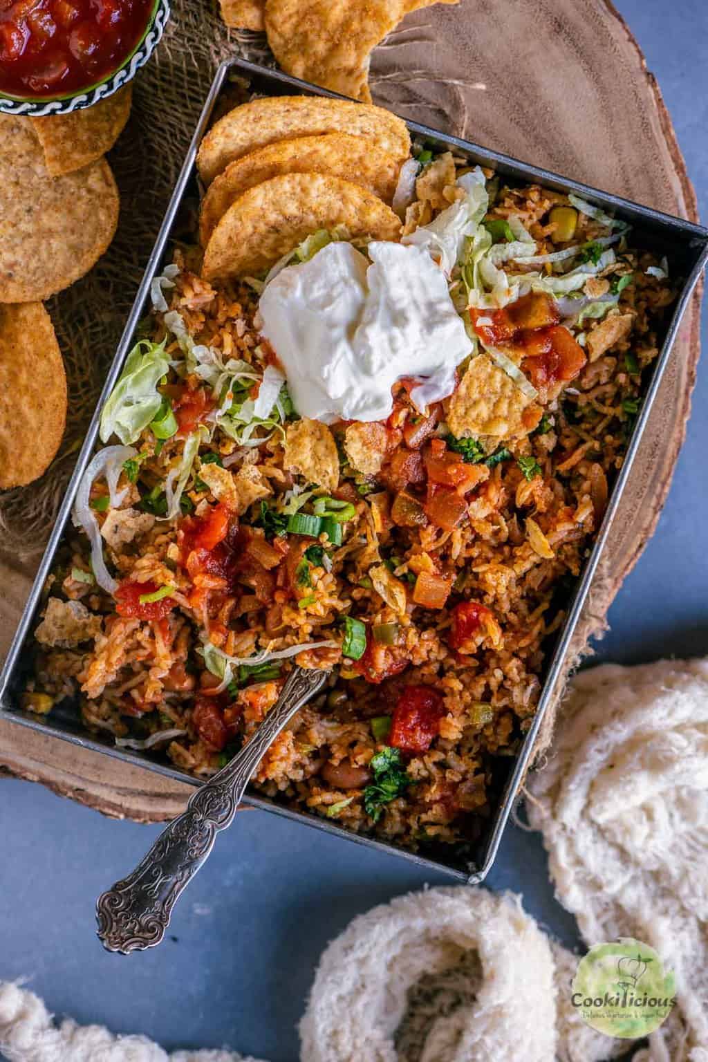 Mexican Fried rice served with sour cream and tortilla chips on top.