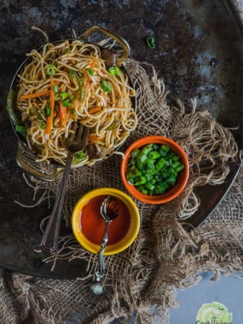 a bowl filled with Veg Hakka Noodles and a fork in it