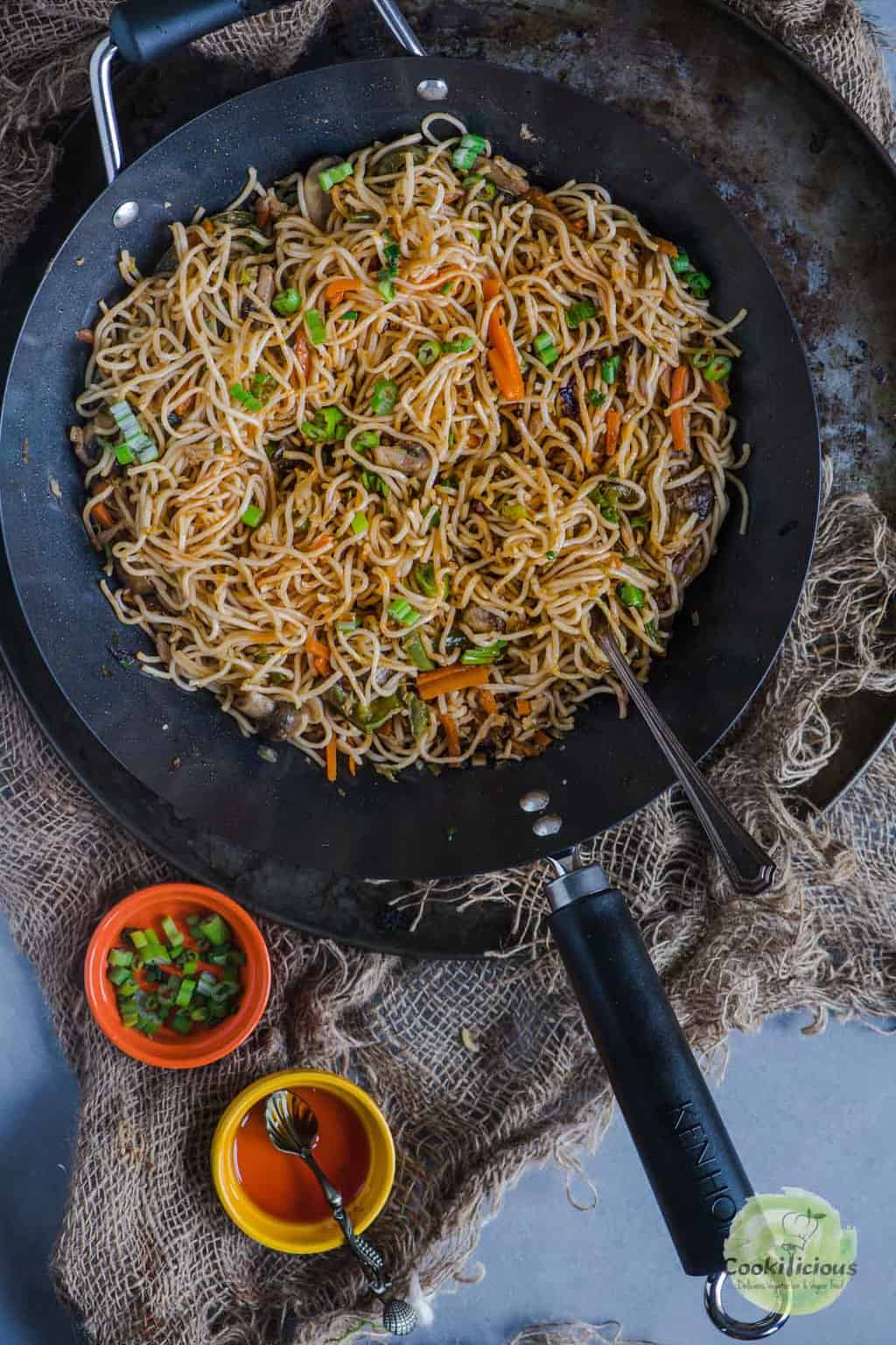 Veg Hakka Noodles in a wok with a fork in it