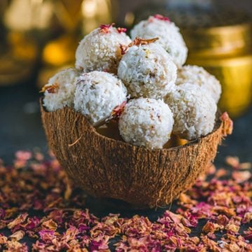 a coconut shell filled with Vegan Coconut Ladoos