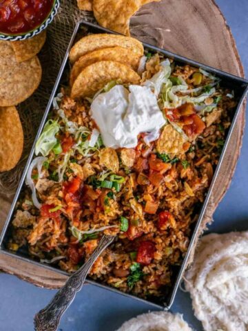 Mexican Fried rice served with sour cream and tortilla chips on top.