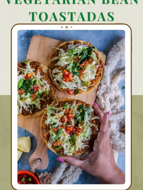one hand picking up one Vegan Corn Tostada from a wooden platter and text at the top and bottom