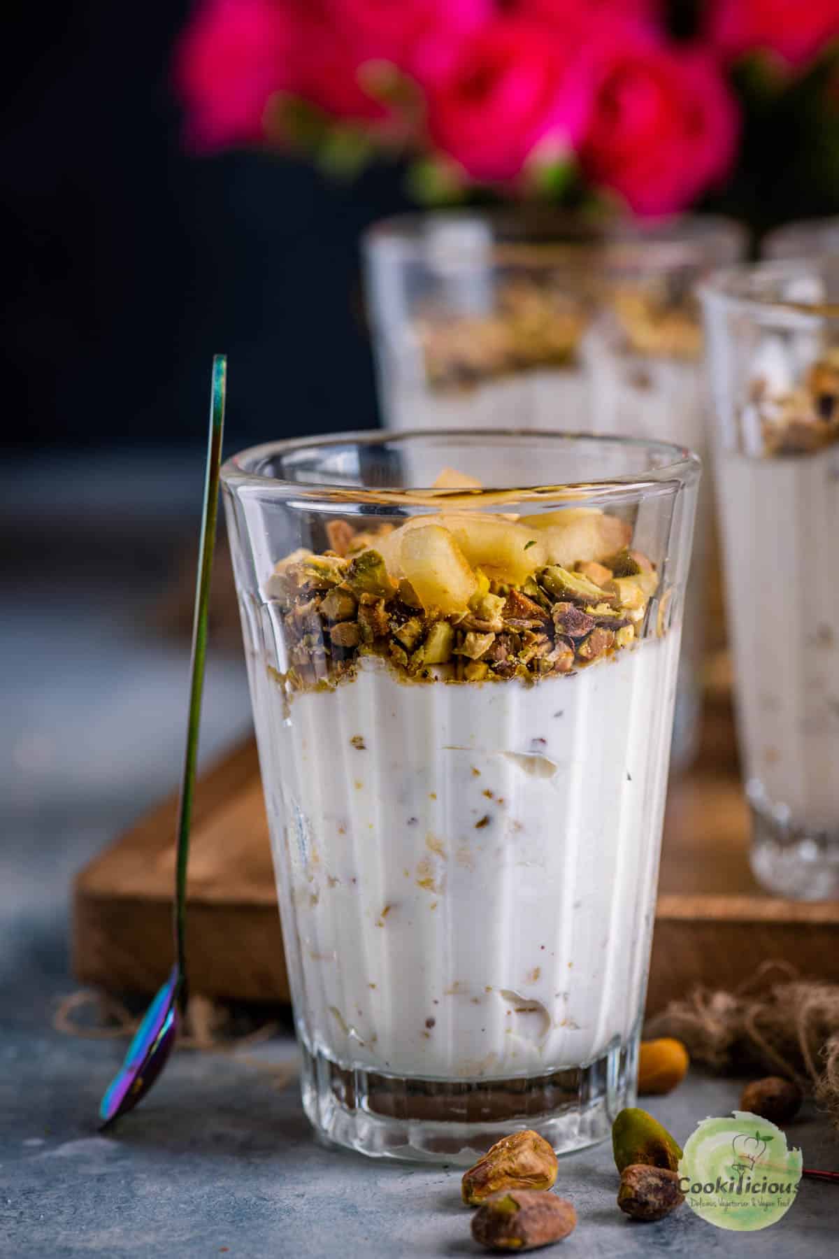 Apple Pistachio Mousse served in a small glass with a spoon resting on it