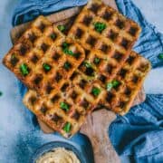 4 Potato Hummus Waffles served on a wooden tray with a bowl of hummus on the side