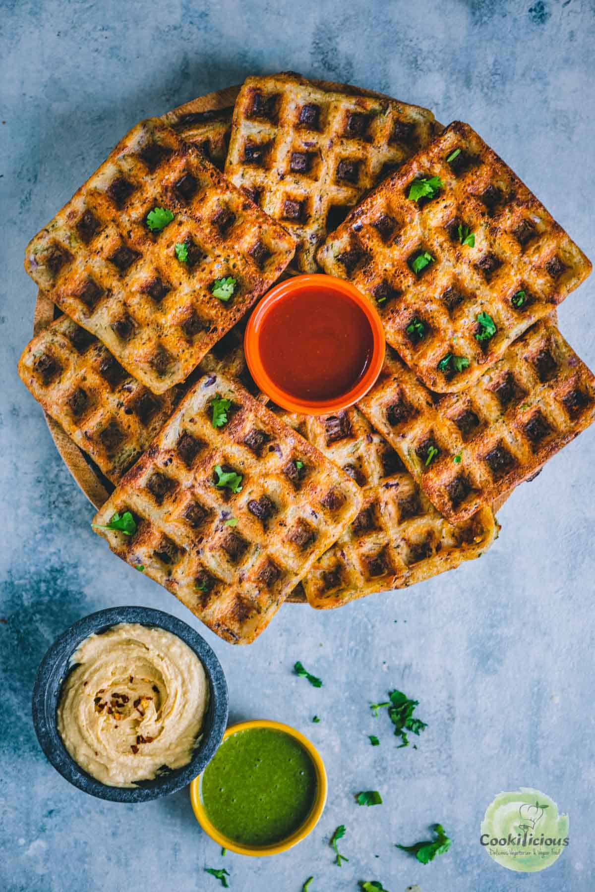 many Potato Hummus Waffles served in a round tray with a bowl of ketchup in the middle