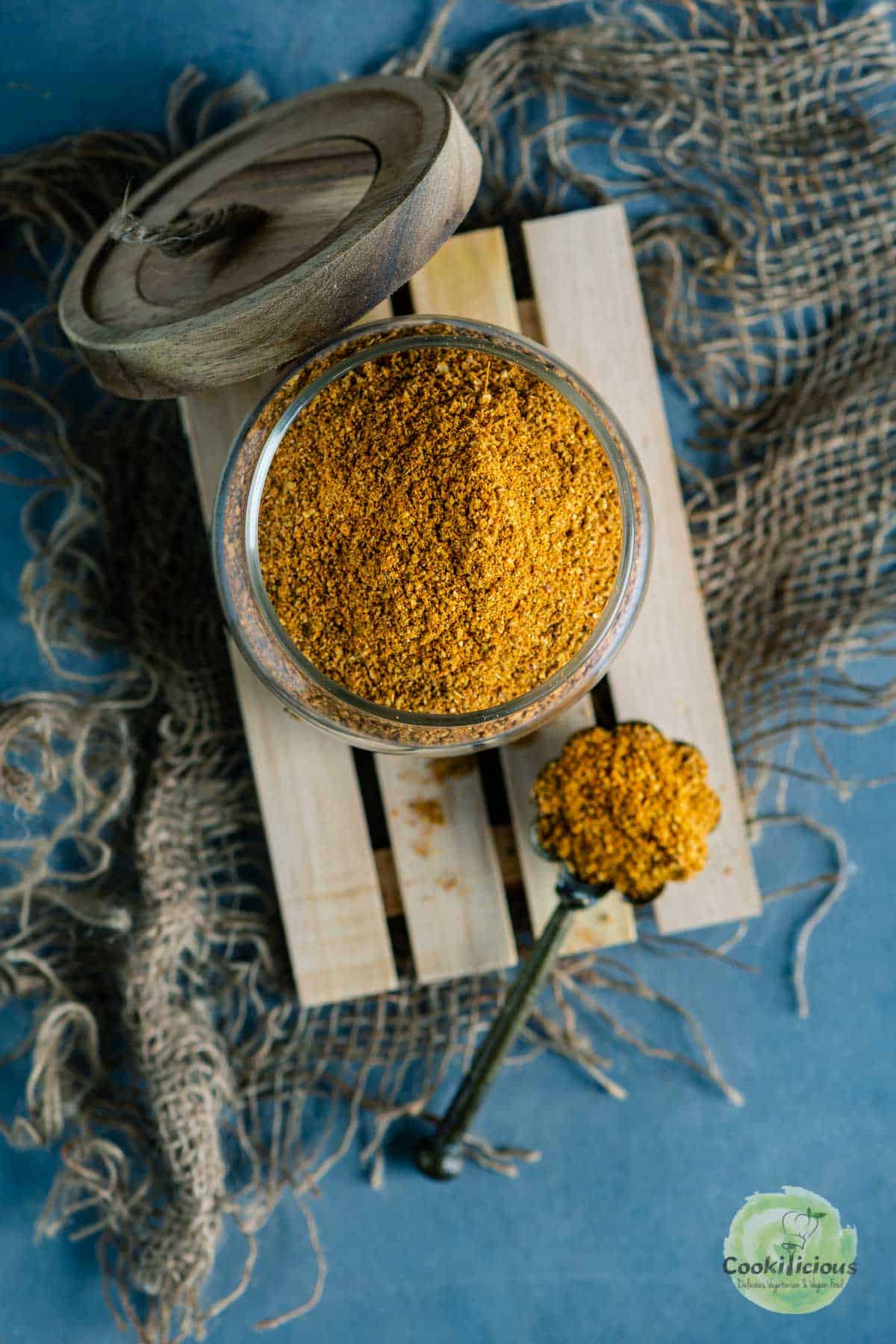 Sambhar Powder stored in a jar with a spoon next to it