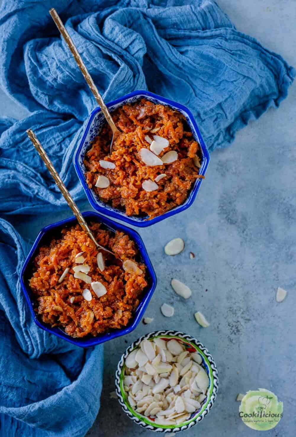 2 bowls of Instant Pot Vegan Carrot Halwa with a bowl of sliced almonds on the side