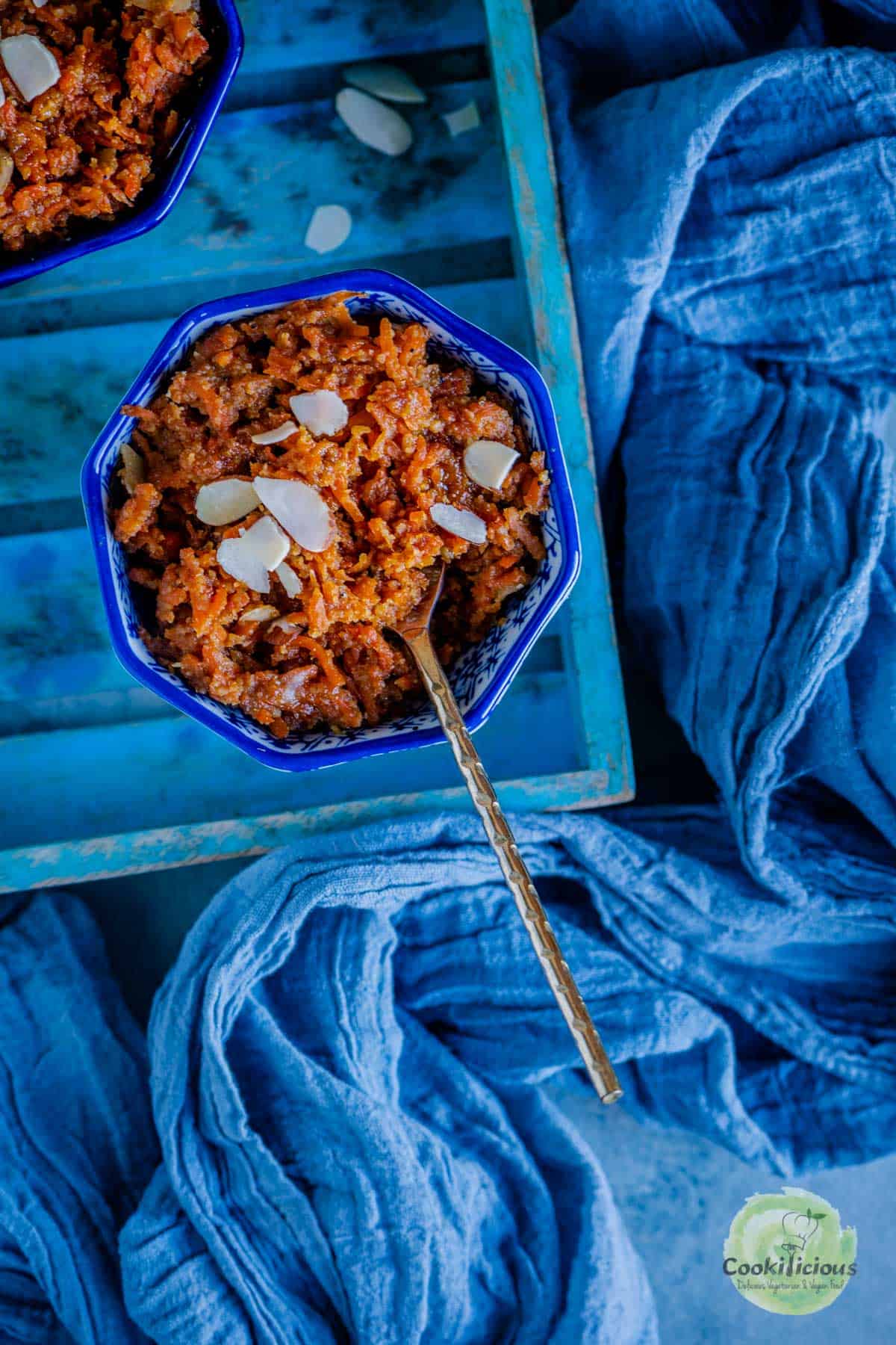 a bowl of carrot halwa with a spoon in it