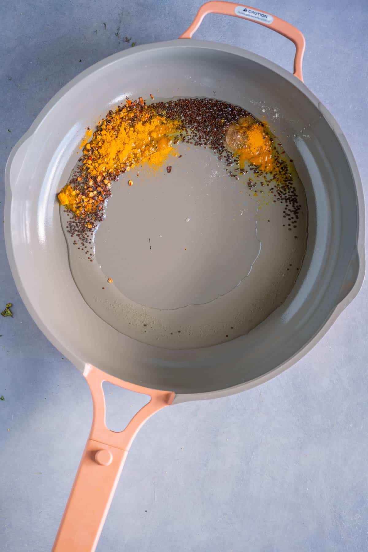 Turmeric and red pepper flakes added to the tempering in a pan.