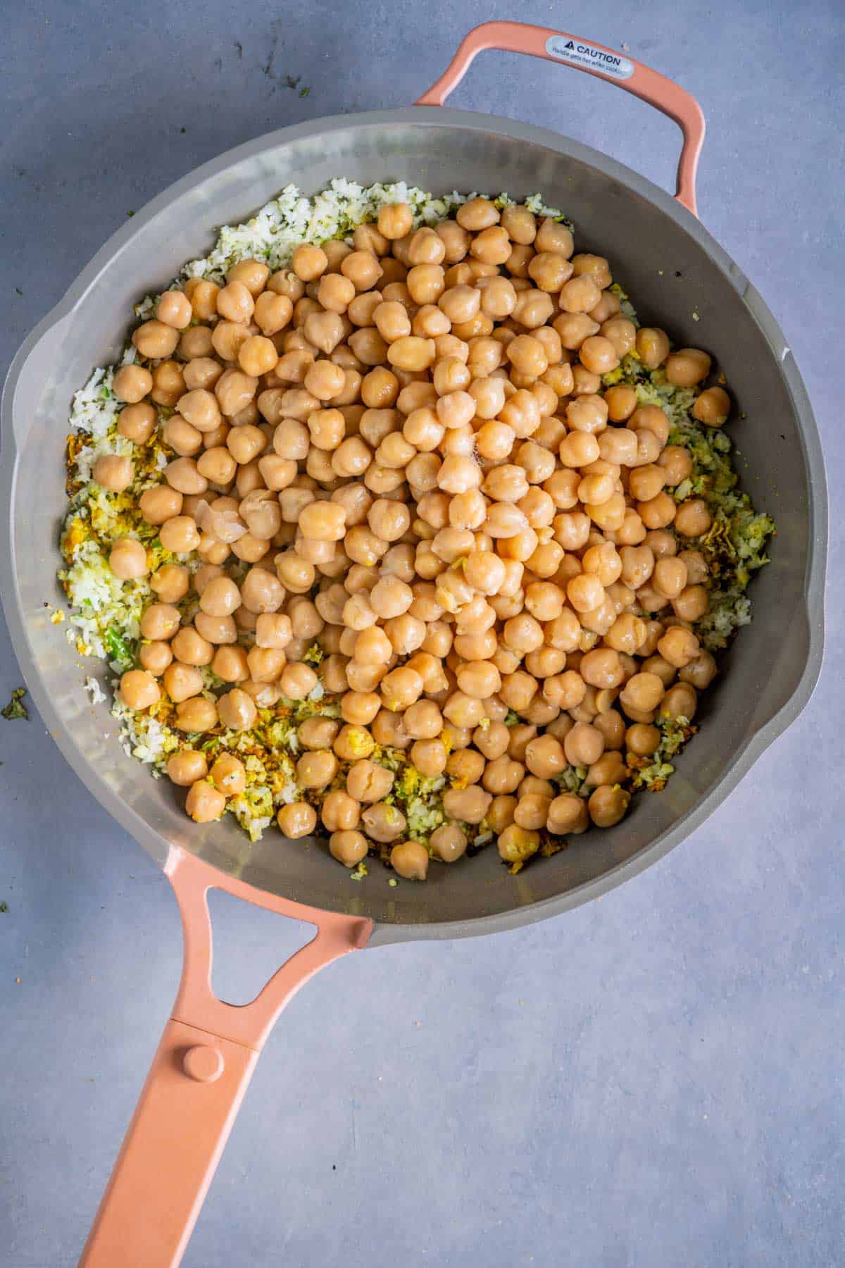 Canned chickpeas added to the sundal masala in a pan.
