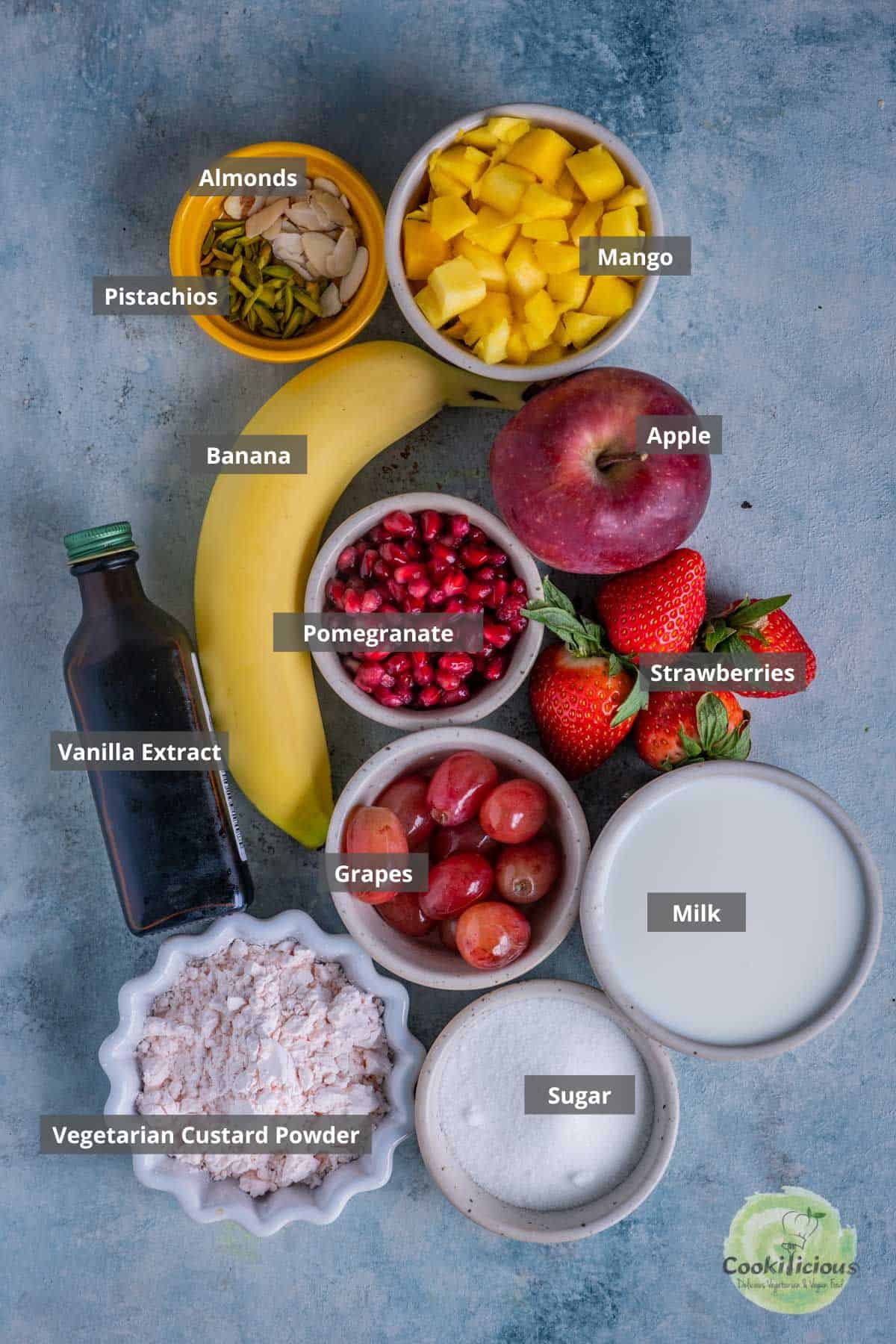 all the ingredients needed to make Indian Fruit Custard placed on a table with labels on them