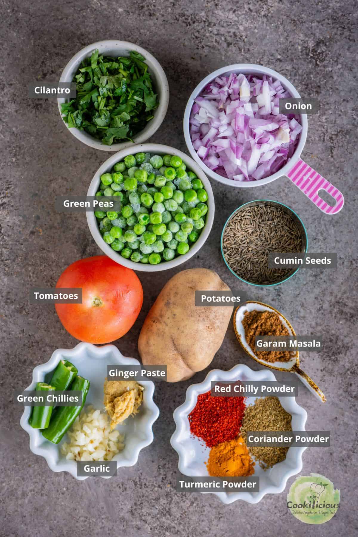 all the ingredients needed to make aloo matar placed on a table with labels on them.