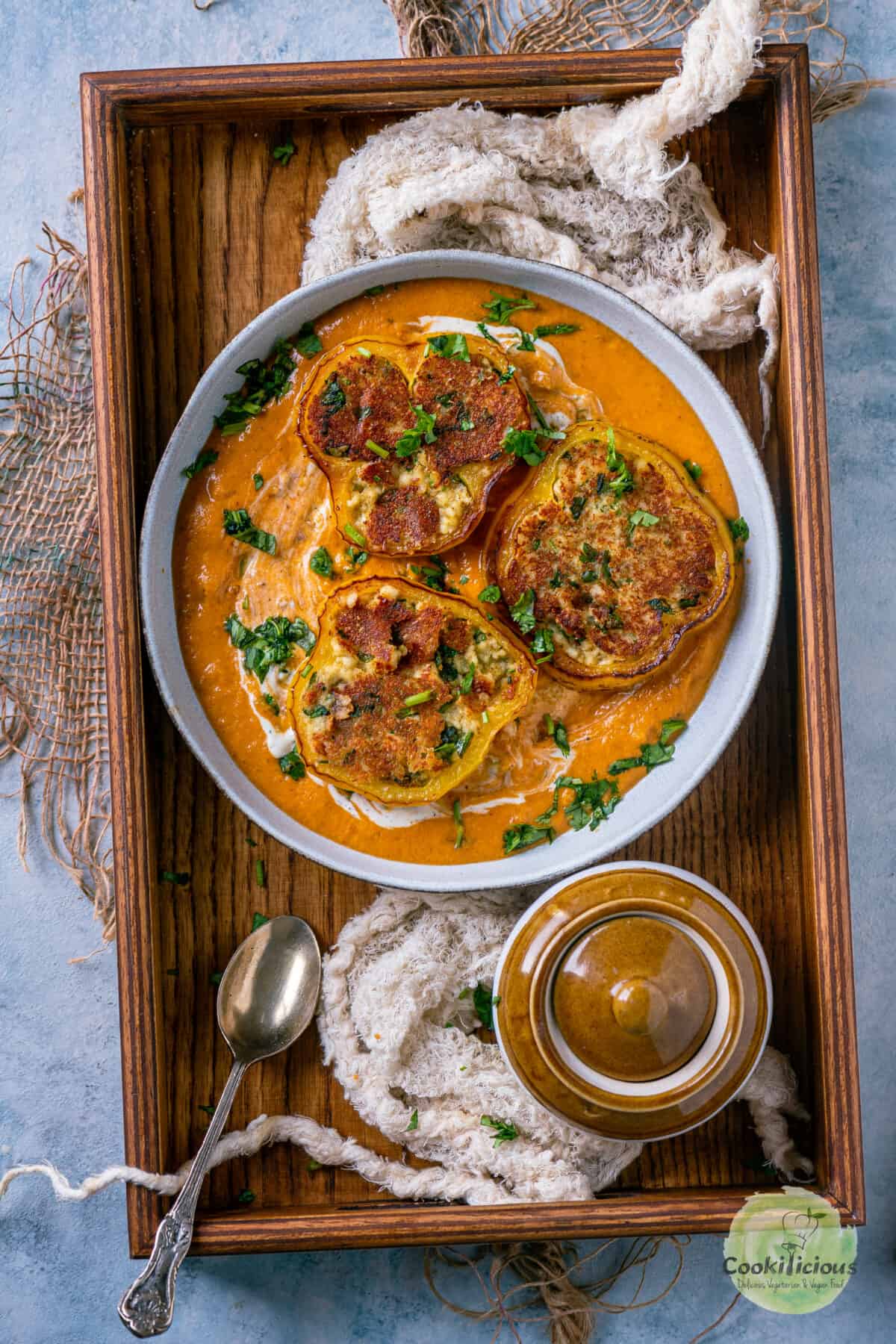 Paneer Masala Stuffed Peppers In Creamy Tomato Gravy placed on a wooden tray.