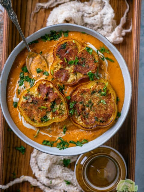 Paneer Masala Stuffed Peppers In Creamy Tomato Gravy served on a wooden tray.