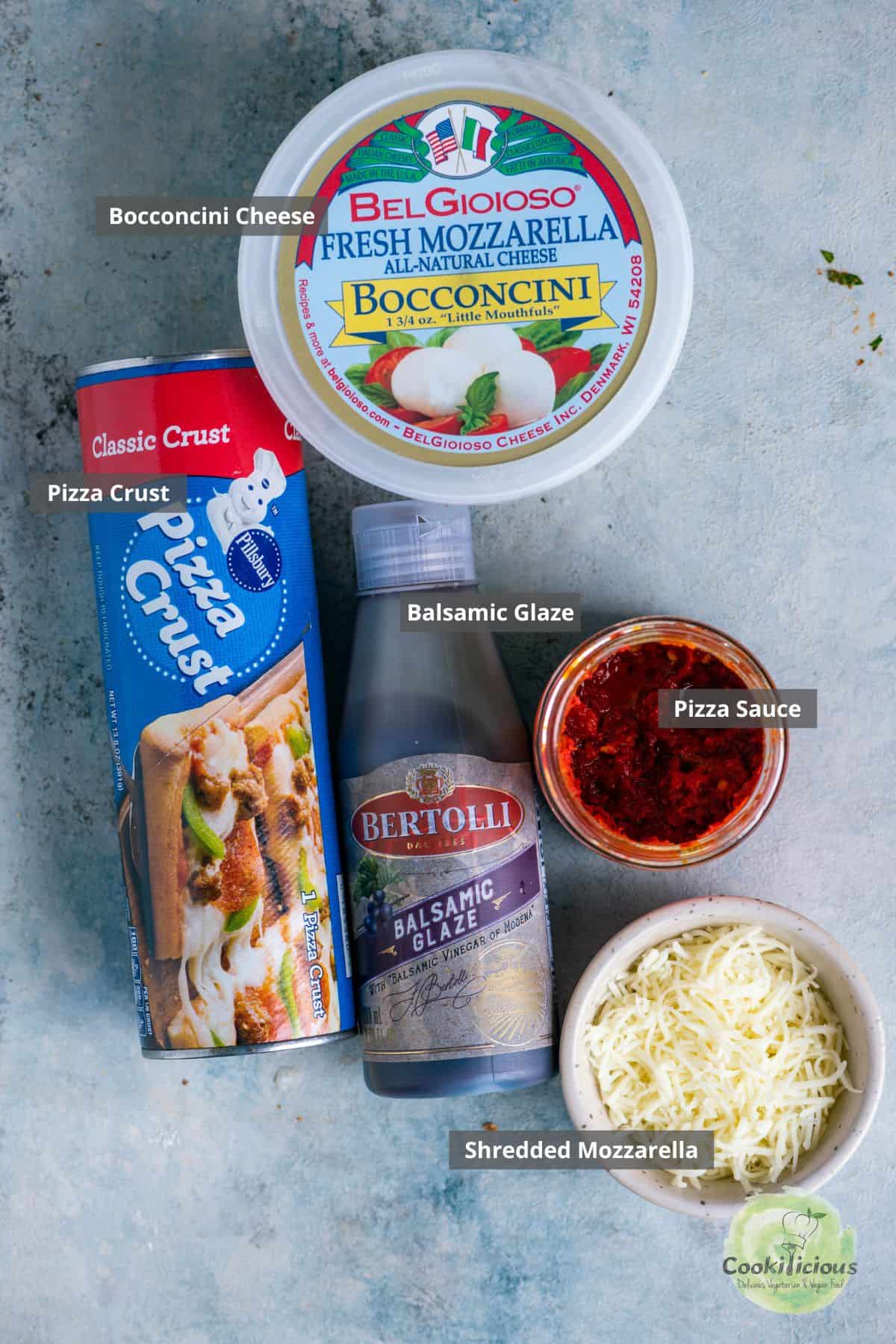 all the ingredients needed to make Easy Tomato Bruschetta Pizza placed on a table with labels on them.
