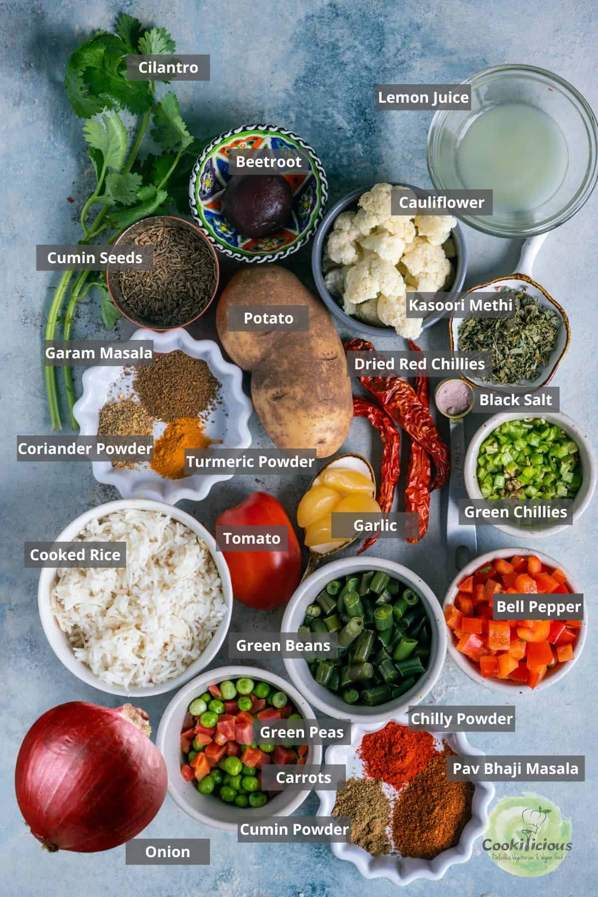 All the ingredients needed to make veg tawa pulao placed on a table with labels on them.
