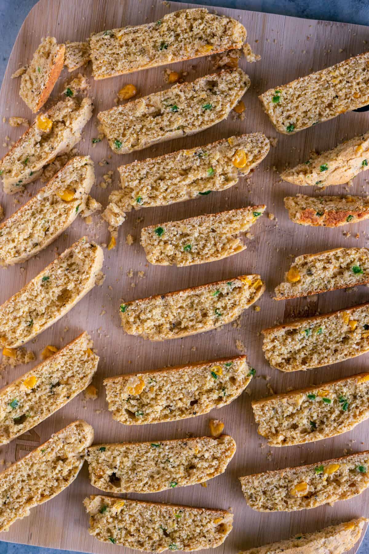 Diagonally sliced jalapeño cheddar cornbread biscotti on a baking sheet for the second bake.