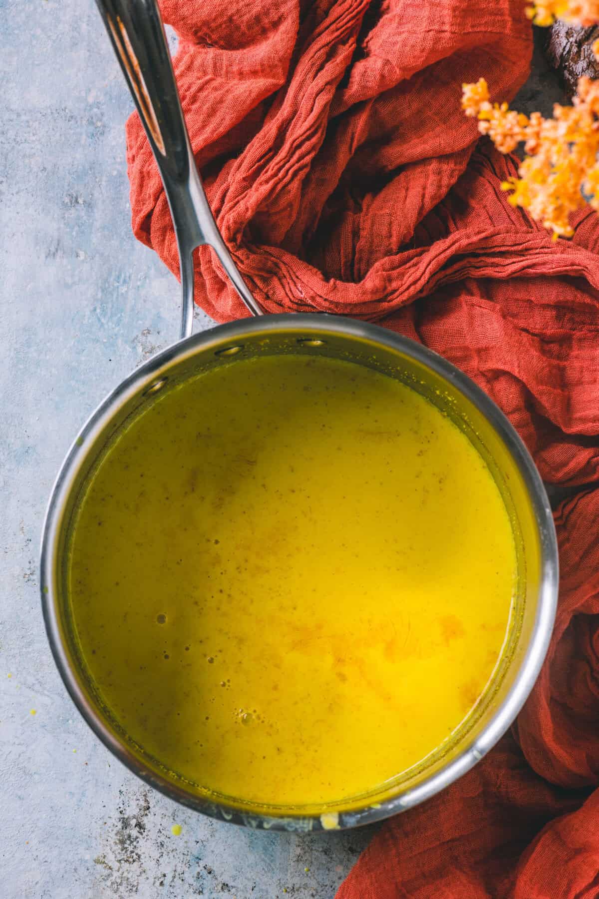 Turmeric milk being whisked and simmered in a pot.