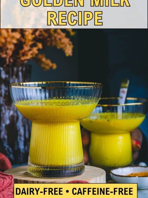 Golden milk recipe served in two ribbed gold-rimmed glasses with a small bowl of turmeric powder.