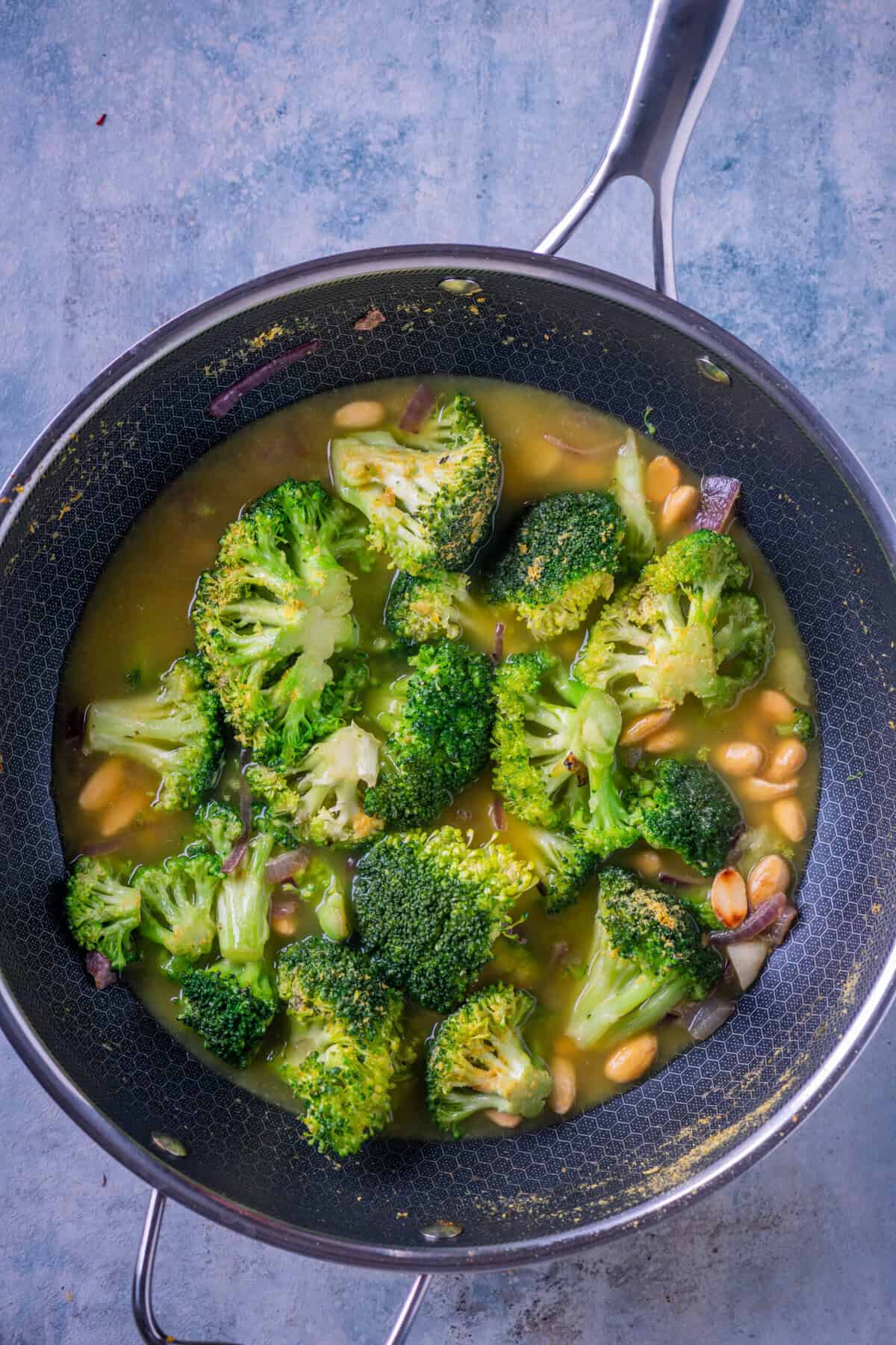 Simmering broccoli in vegetable stock for creamy broccoli soup vegan.