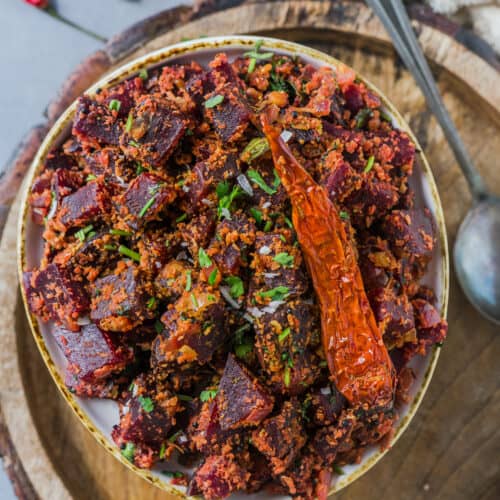 Beetroot Poriyal served in a plate with a dried red chilly on top.