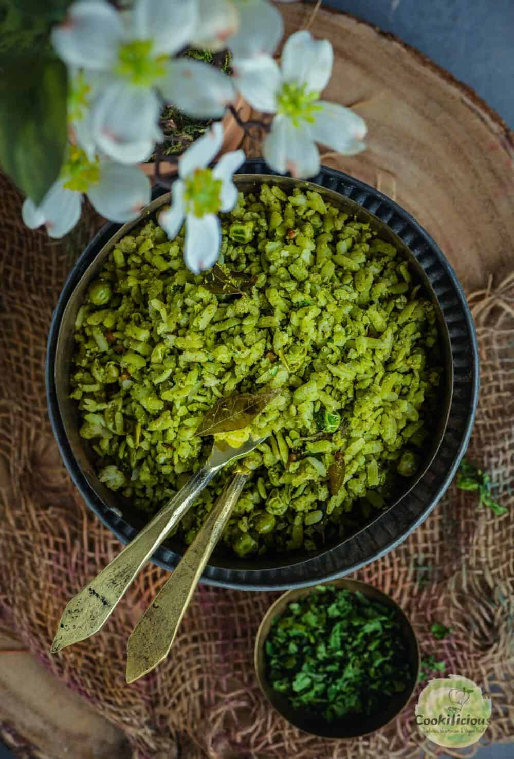 Coriander Poha served in a bowl with 3 spoons in it.
