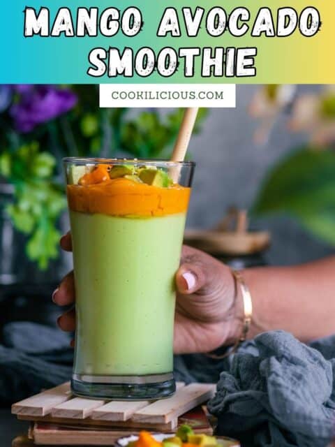 A hand holding a glass that's filled with avocado and mango smoothie and text at the top.