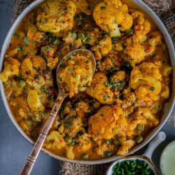 Vegan Cauliflower Tikka Masala served in a bowl with a spoon in it.