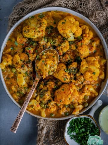 Vegan Cauliflower Tikka Masala served in a bowl with a spoon in it.