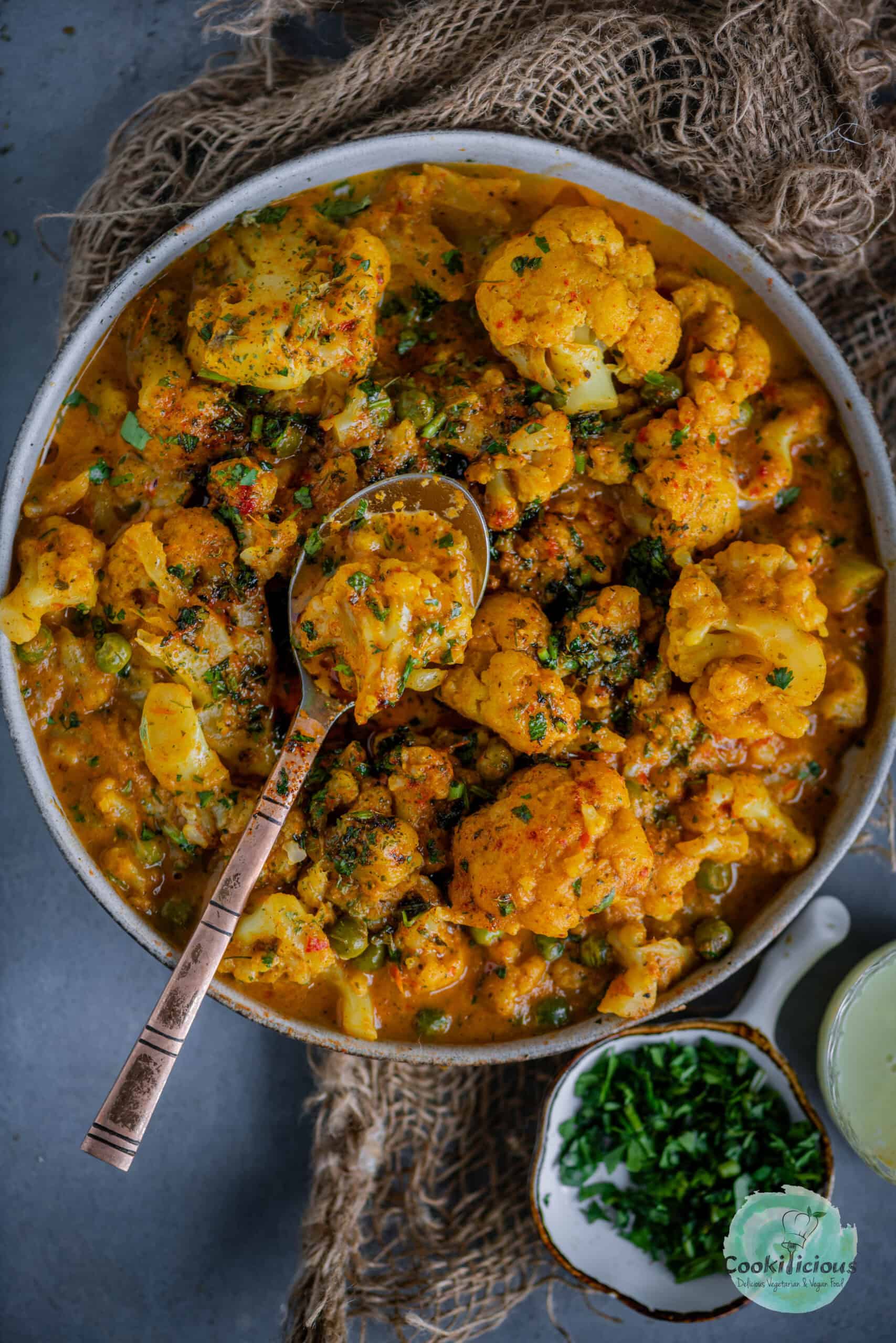 Vegan Cauliflower Tikka Masala served in a bowl with a spoon in it.