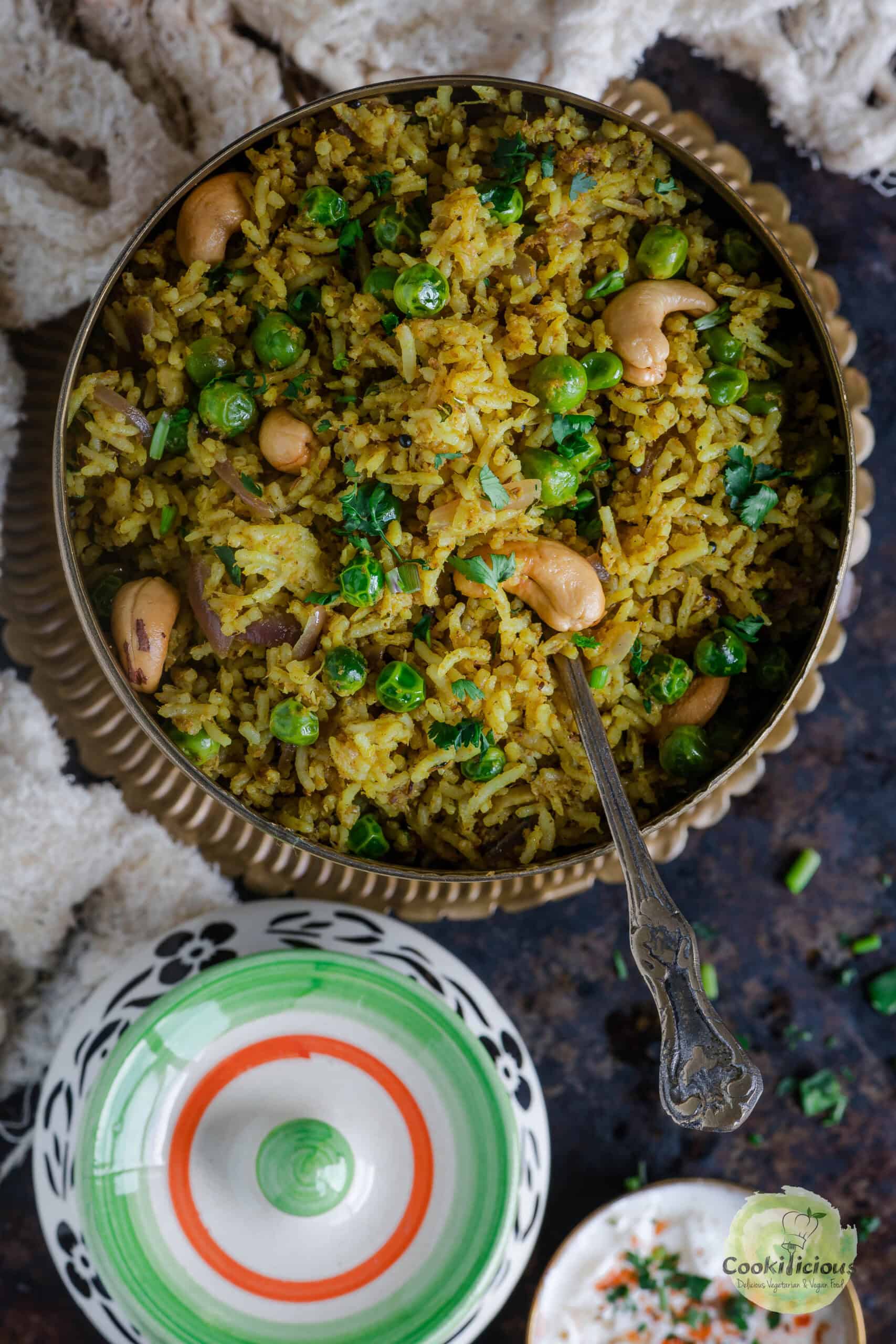 Matar pulao served in a round bowl with a spoon in it,