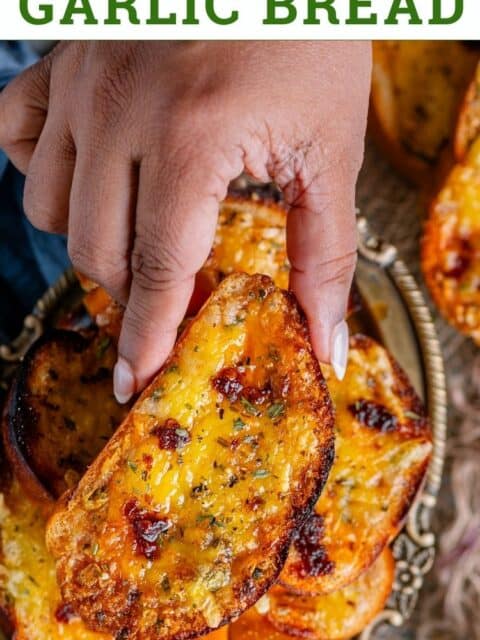 A hand holding one vegan garlic bread and text at the top.