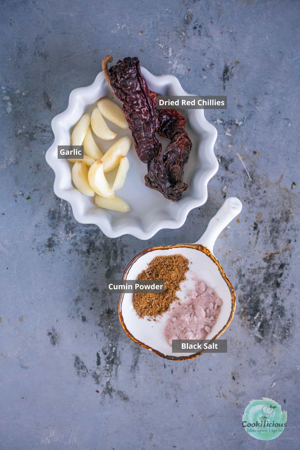 all the ingredients needed to make the red garlic Bhel Puri chutney placed on a table with labels on them.