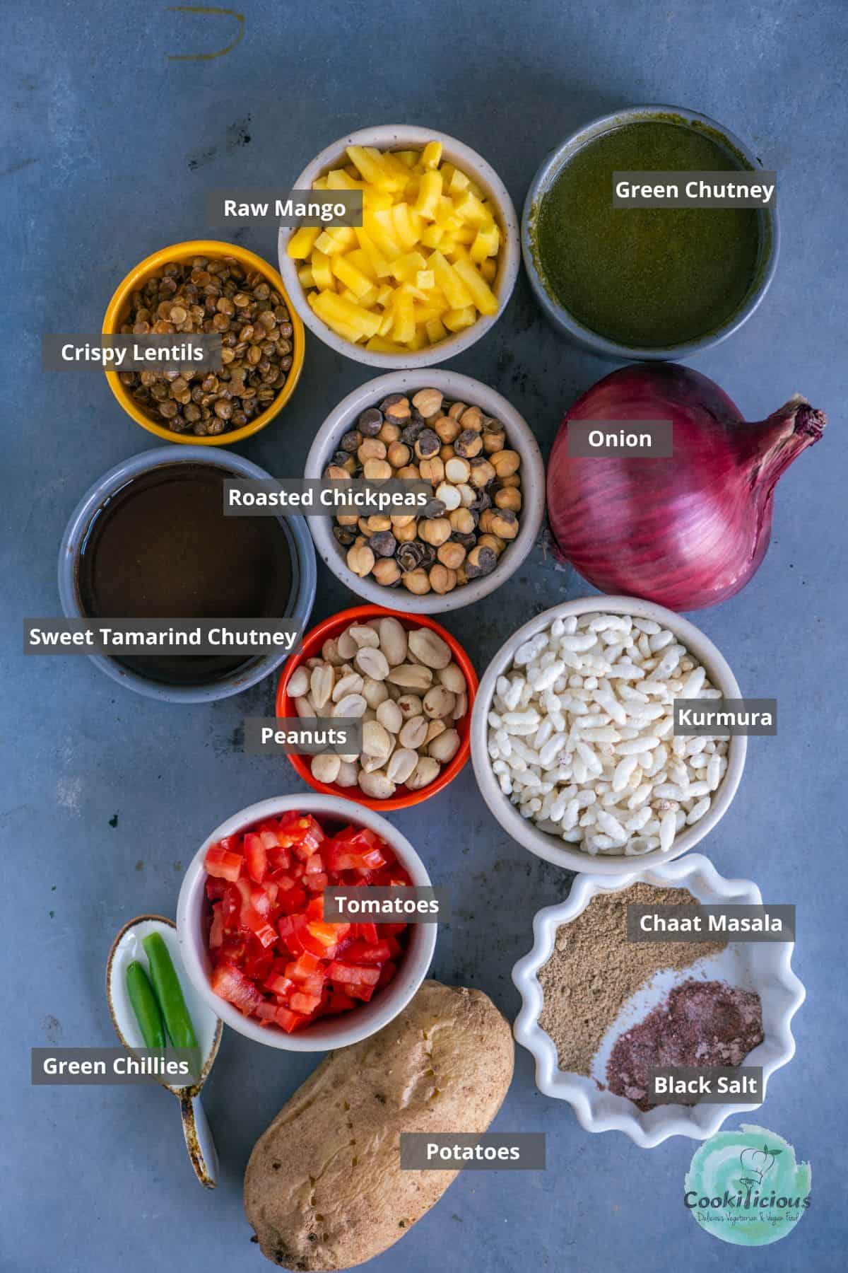 All the ingredients needed in the Bhel Puri recipe placed on a table with labels on them.