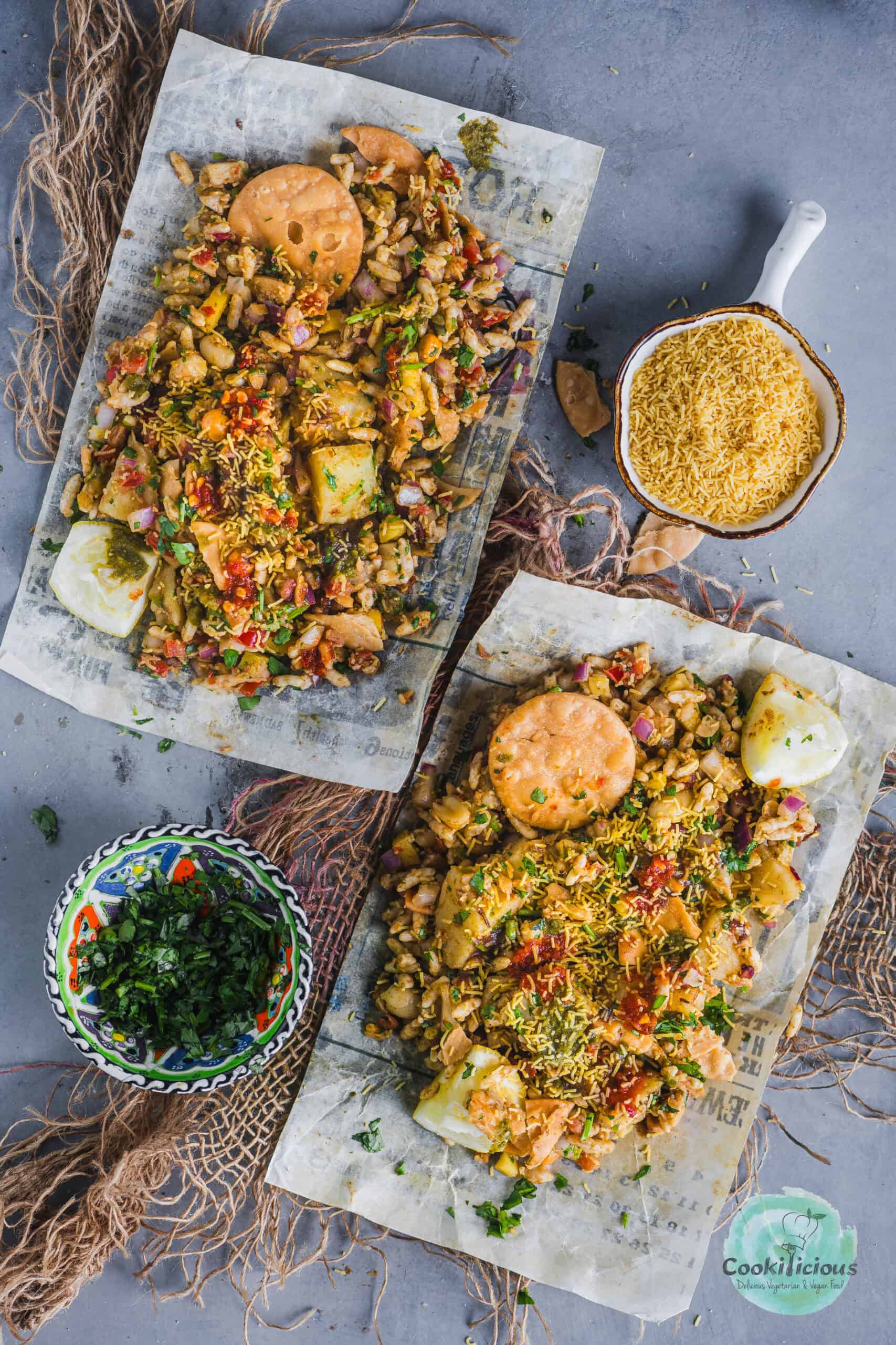 Authentic Mumbai Bhel Puri with puffed rice, chutneys, and fresh veggies, served on two paper plates with Papdi.