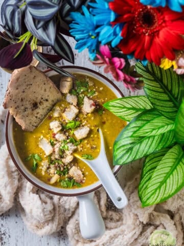 Indian Lentil Soup served in a bowl with bread.